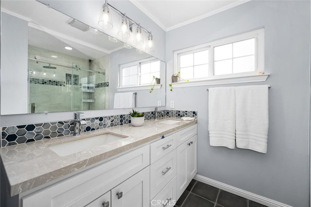 bathroom with a shower stall, crown molding, a sink, and tile patterned floors