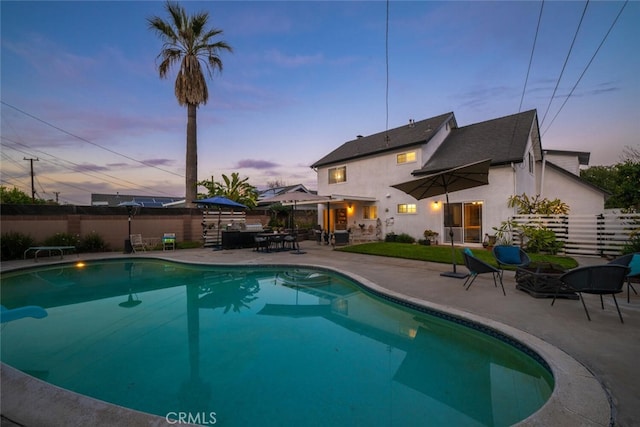 view of swimming pool with a diving board, a patio, fence, and a fenced in pool