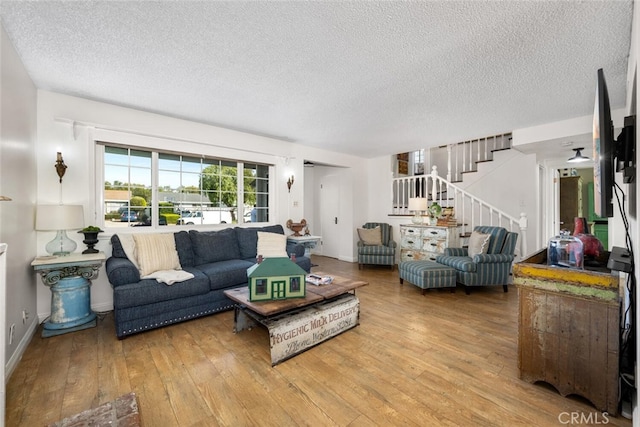 living area featuring stairs, a textured ceiling, and wood-type flooring