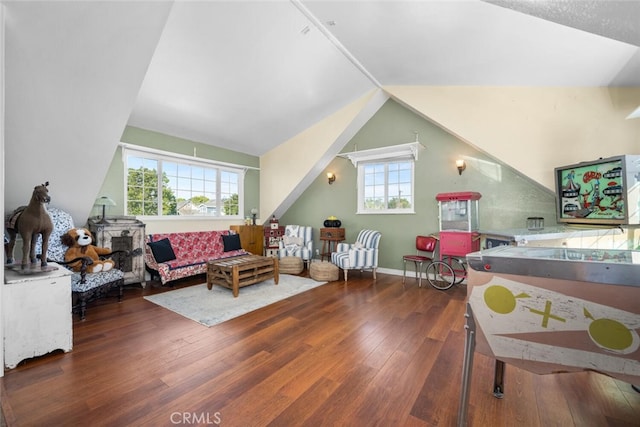 living room featuring lofted ceiling, baseboards, and hardwood / wood-style flooring