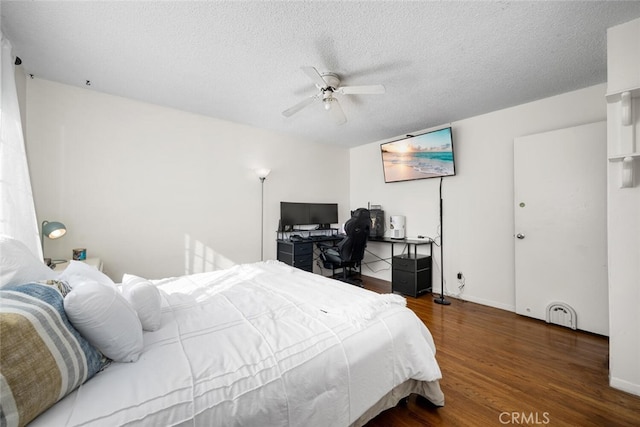 bedroom with a ceiling fan, a textured ceiling, baseboards, and wood finished floors