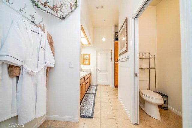 bathroom with vanity, baseboards, visible vents, tile patterned floors, and toilet