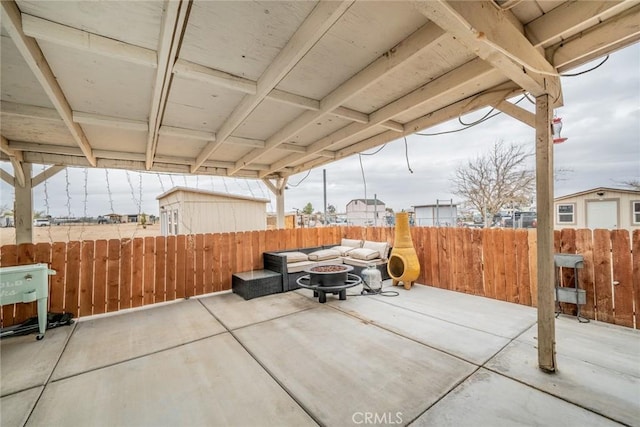 view of patio featuring an outdoor fire pit and fence