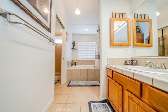 full bath with tile patterned floors, vanity, and tiled bath