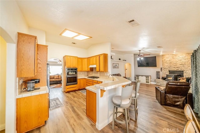 kitchen with arched walkways, visible vents, and a peninsula