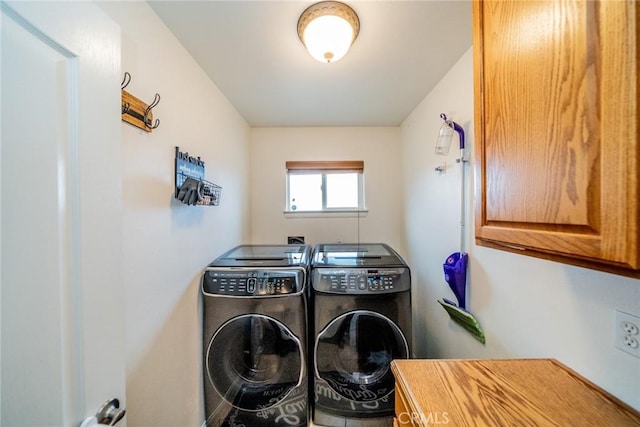 washroom featuring cabinet space and washing machine and clothes dryer