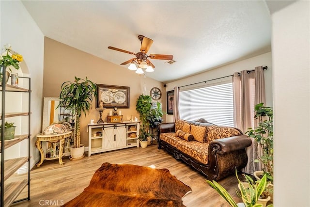 living area with lofted ceiling, light wood-style floors, visible vents, and ceiling fan