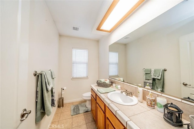 bathroom featuring visible vents, toilet, tile patterned flooring, baseboards, and vanity