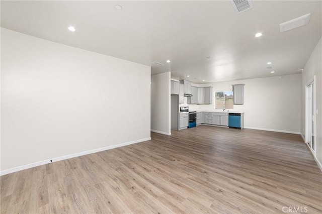 unfurnished living room with light wood-type flooring, visible vents, baseboards, and recessed lighting