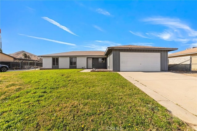 ranch-style house featuring driveway, a front lawn, an attached garage, and fence