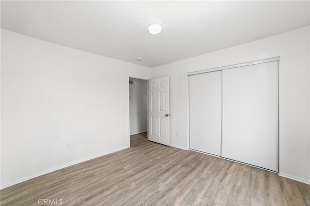 unfurnished bedroom with a closet and wood finished floors
