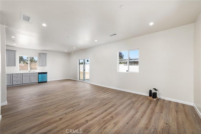 unfurnished living room featuring light wood finished floors, visible vents, baseboards, and recessed lighting