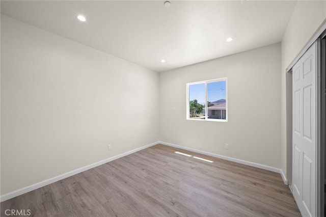 unfurnished bedroom with recessed lighting, baseboards, and wood finished floors