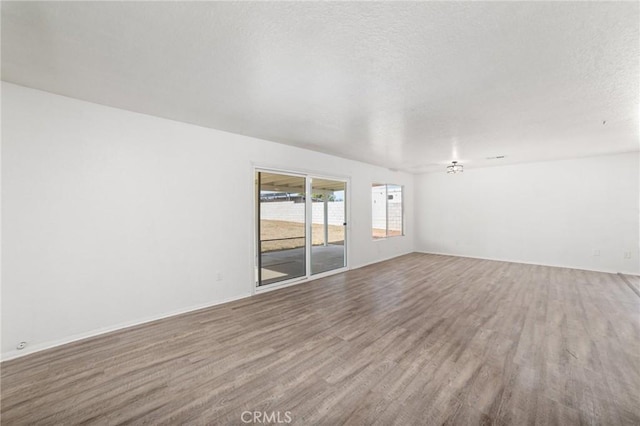 unfurnished room featuring a textured ceiling and wood finished floors