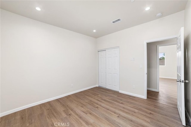 unfurnished bedroom with recessed lighting, visible vents, baseboards, and wood finished floors
