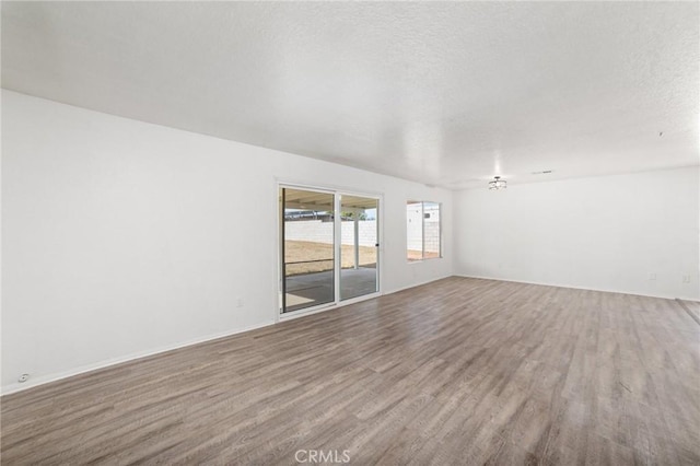 empty room featuring a textured ceiling and wood finished floors