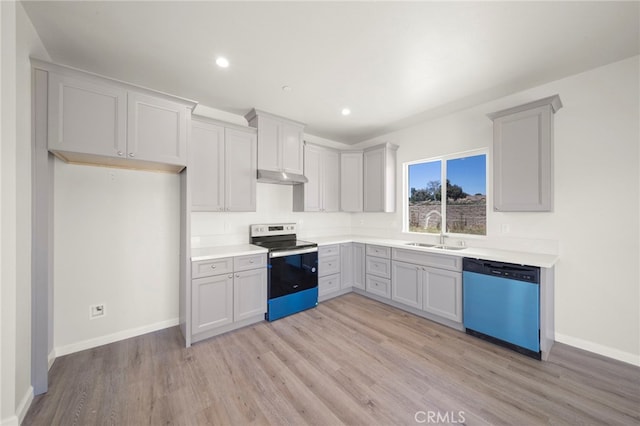 kitchen featuring under cabinet range hood, a sink, stainless steel electric range, dishwasher, and light wood finished floors