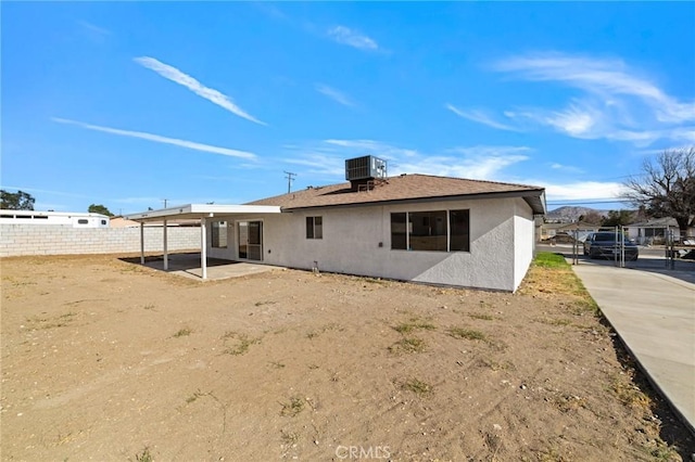 back of house featuring central air condition unit, a patio area, fence, and stucco siding