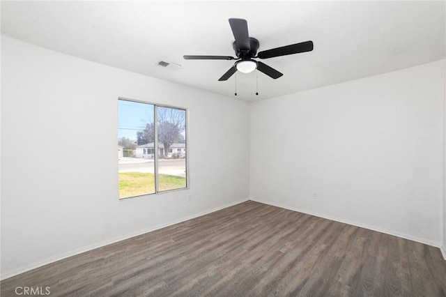 spare room with baseboards, visible vents, ceiling fan, and wood finished floors
