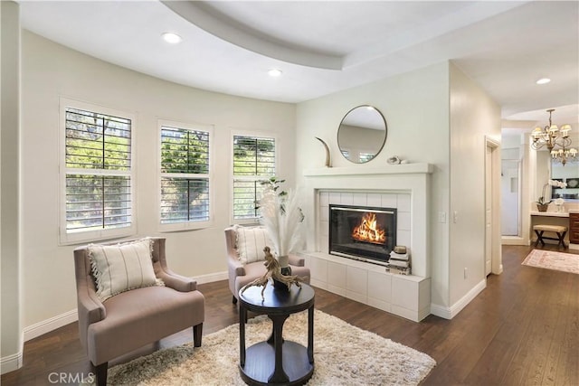 living area featuring wood-type flooring, baseboards, a tiled fireplace, and recessed lighting