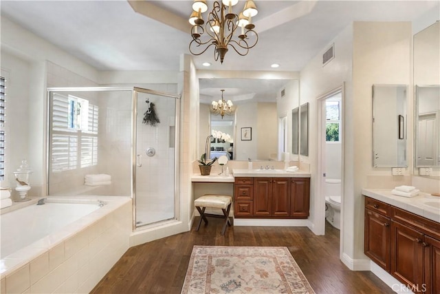 bathroom with a chandelier, a stall shower, wood finished floors, and a bath