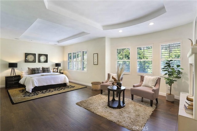 bedroom featuring baseboards, a tray ceiling, dark wood finished floors, and recessed lighting