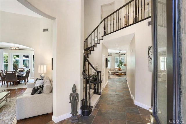 foyer entrance featuring plenty of natural light, stairs, baseboards, and visible vents