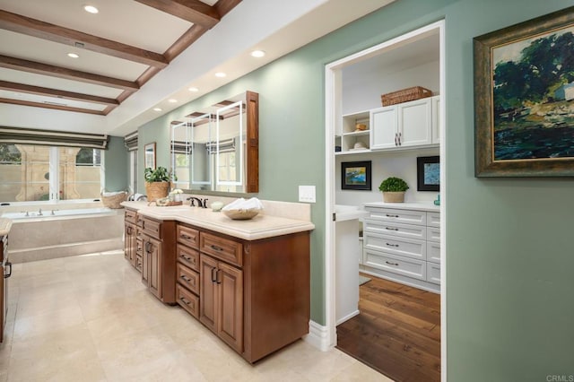 bathroom featuring a garden tub, vanity, and recessed lighting