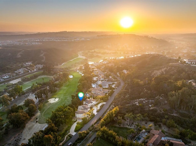 aerial view at dusk with a residential view, a mountain view, and view of golf course
