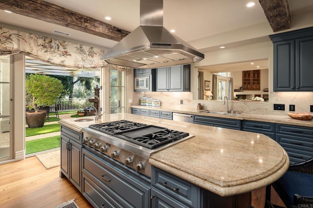 kitchen featuring island exhaust hood, stainless steel appliances, a sink, beam ceiling, and tasteful backsplash