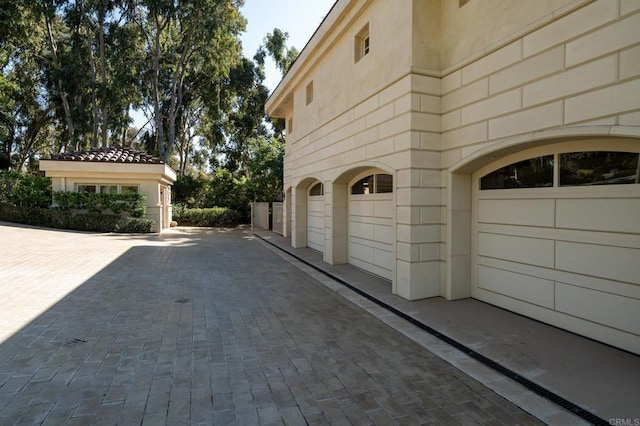 view of property exterior featuring an attached garage and stucco siding