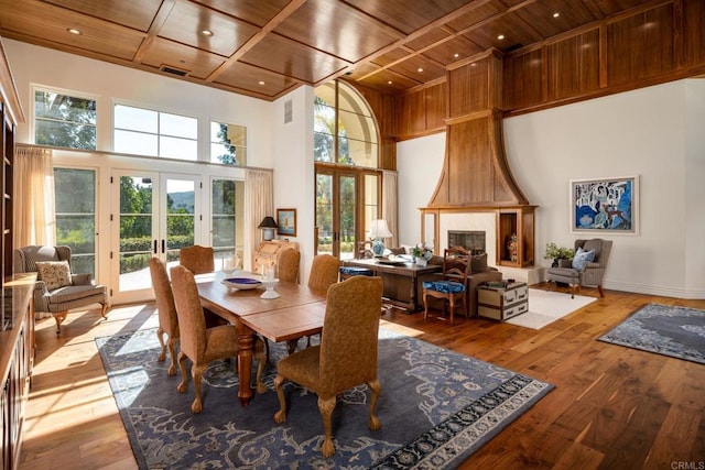 14479 Emerald Ln, Rancho Santa Fe, CA 92067 - dining room with wood ceiling with exposed beams, wood-type flooring, french doors, healthy amount of natural light, and a fireplace