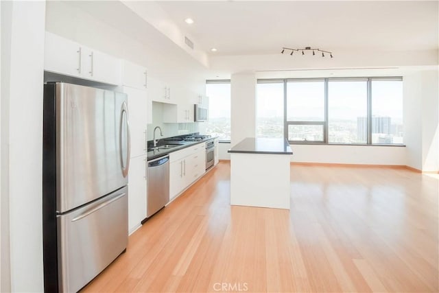 kitchen with visible vents, appliances with stainless steel finishes, light wood-style floors, white cabinetry, and a sink