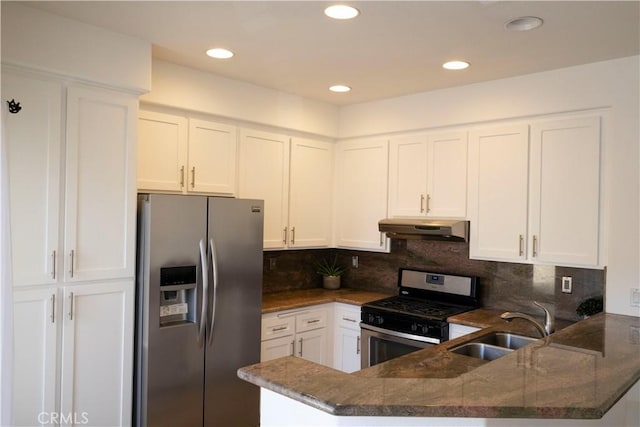 kitchen with appliances with stainless steel finishes, a sink, dark stone countertops, a peninsula, and under cabinet range hood