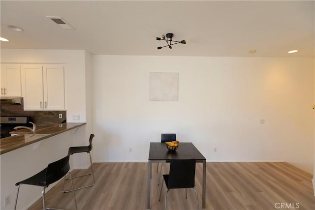 interior space featuring light wood-type flooring, visible vents, and recessed lighting