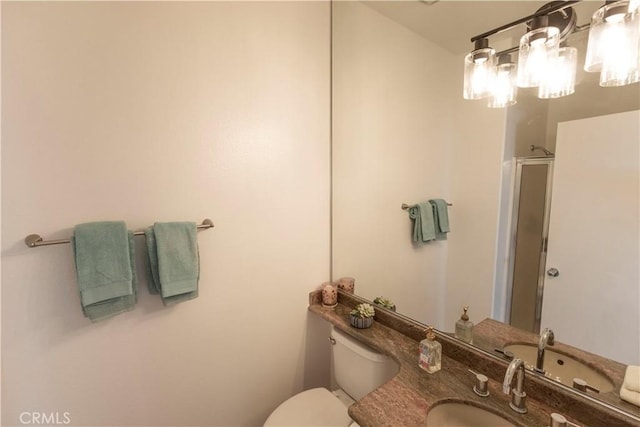 bathroom with a stall shower, vanity, and toilet