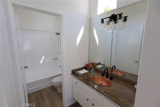 full bath with  shower combination, vanity, toilet, and wood finished floors