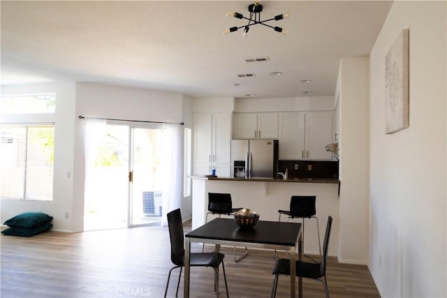 dining area featuring visible vents and wood finished floors