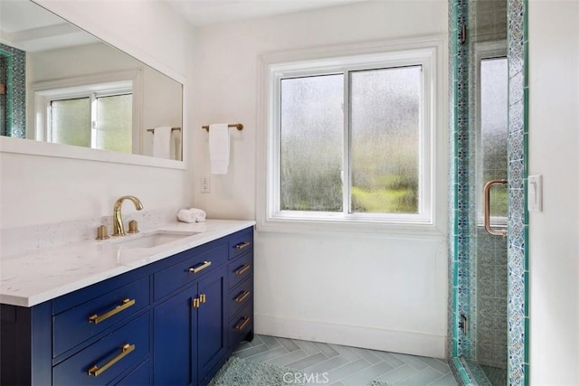 bathroom with a stall shower, baseboards, and vanity