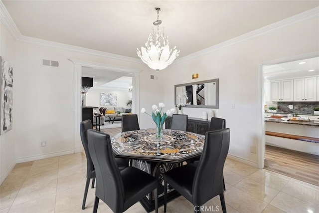 dining space with light tile patterned floors, baseboards, crown molding, and an inviting chandelier