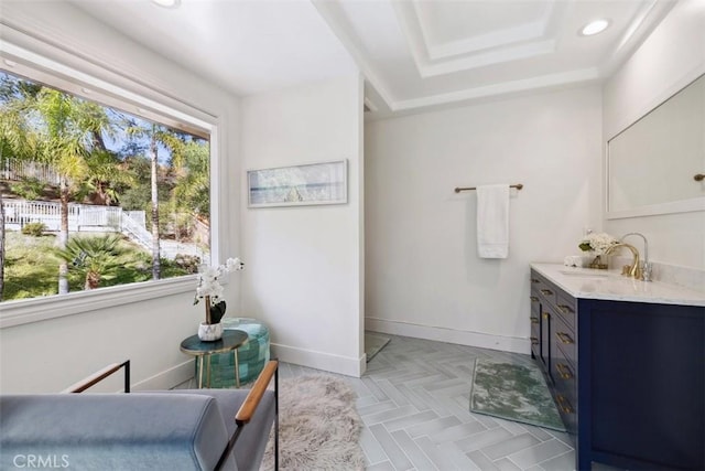 bathroom featuring recessed lighting, a raised ceiling, vanity, and baseboards