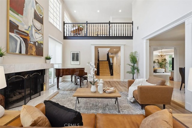 living area featuring a healthy amount of sunlight, stairs, a fireplace, and wood finished floors