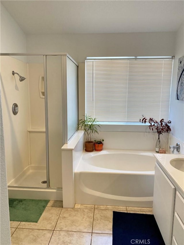 full bath featuring a garden tub, tile patterned flooring, vanity, and a shower stall