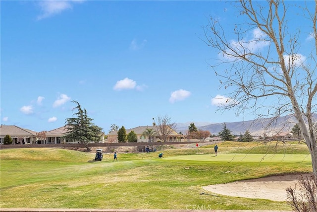 view of property's community featuring a lawn and a mountain view