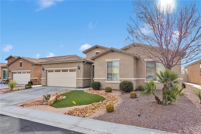 view of front of house with concrete driveway, a tile roof, an attached garage, and stucco siding