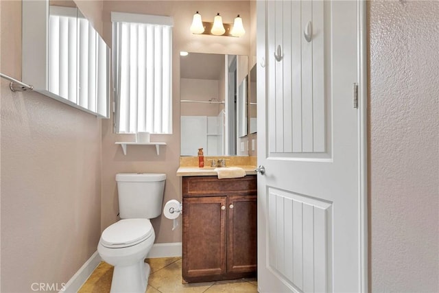 bathroom featuring toilet, vanity, baseboards, and tile patterned floors