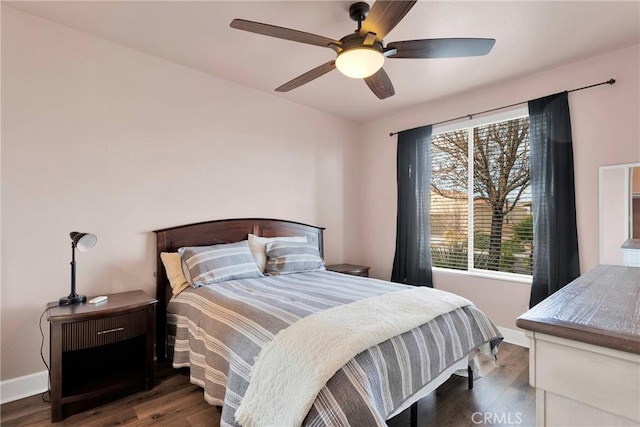 bedroom with a ceiling fan, baseboards, and wood finished floors