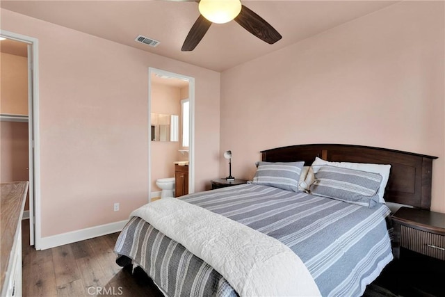 bedroom featuring baseboards, visible vents, a ceiling fan, ensuite bath, and wood finished floors