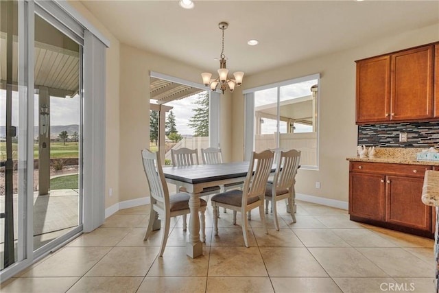 dining room featuring baseboards, a chandelier, and light tile patterned flooring