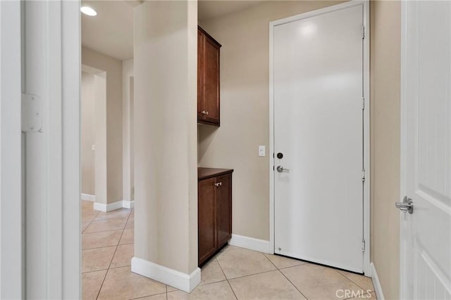 interior space with light tile patterned floors and baseboards